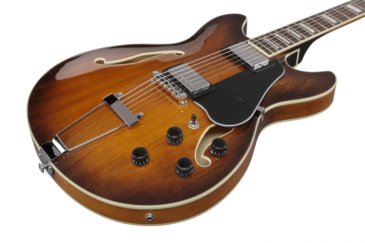 Close-up of the Ibanez AS7328 body featuring dual Classic Elite humbucker pickups, a Gibraltar Performer bridge, and a vintage-style VT06 trapeze tailpiece.