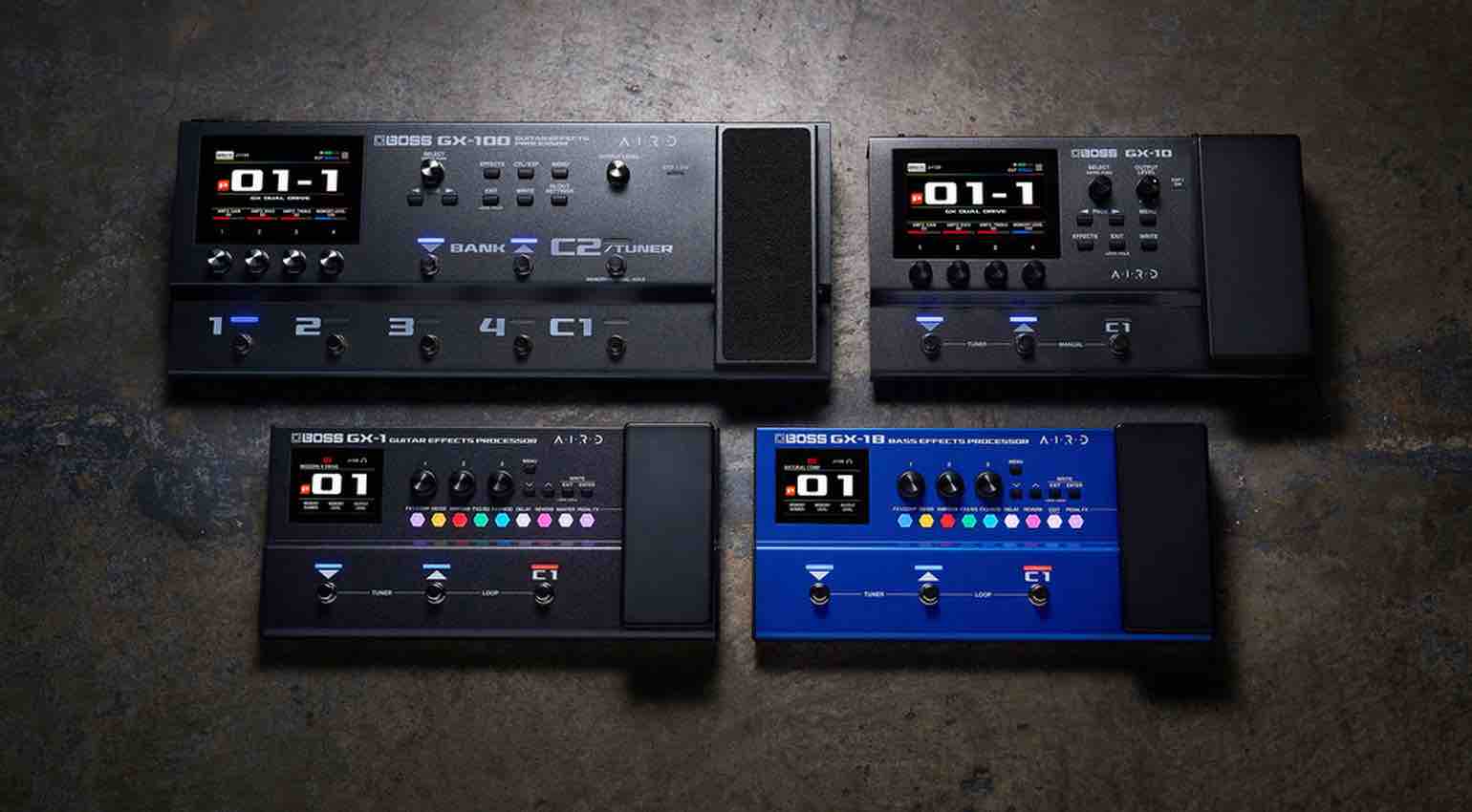 Top-down view of the Boss GX-1 guitar and GX-1B bass multi-effects processors showing the color display, three footswitches, and built-in expression pedal.