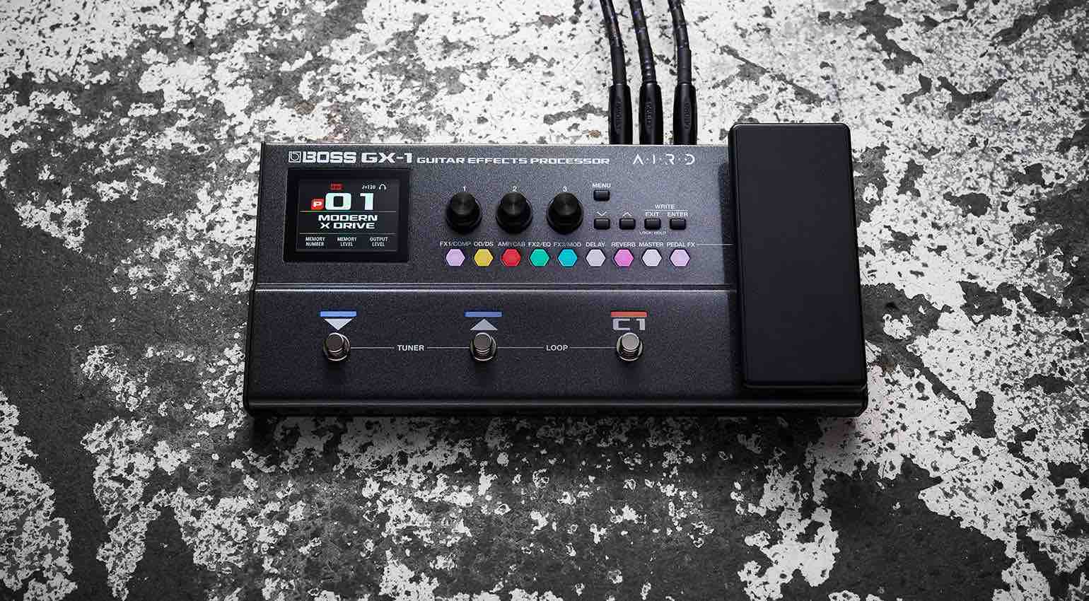 Top-down view of the Boss GX-1 guitar multi-effects processors showing the color display, three footswitches, and built-in expression pedal.