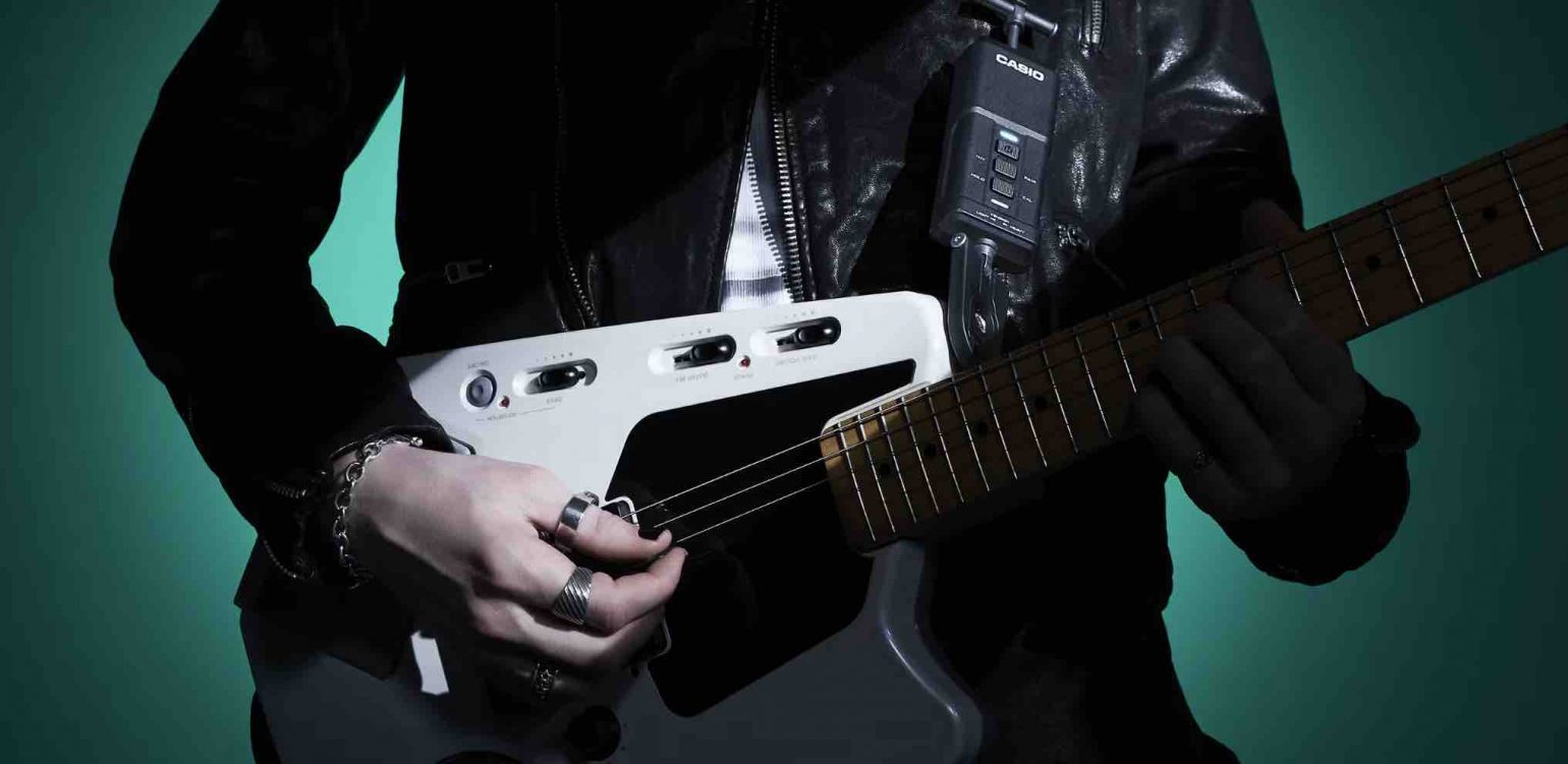 Casio Dimension Shifter wireless expression controller mounted on a guitar strap with its companion floor receiver.