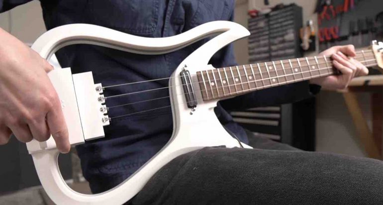 Close-up of industrial-strength magnets holding guitar strings in tension without physical contact to the bridge.