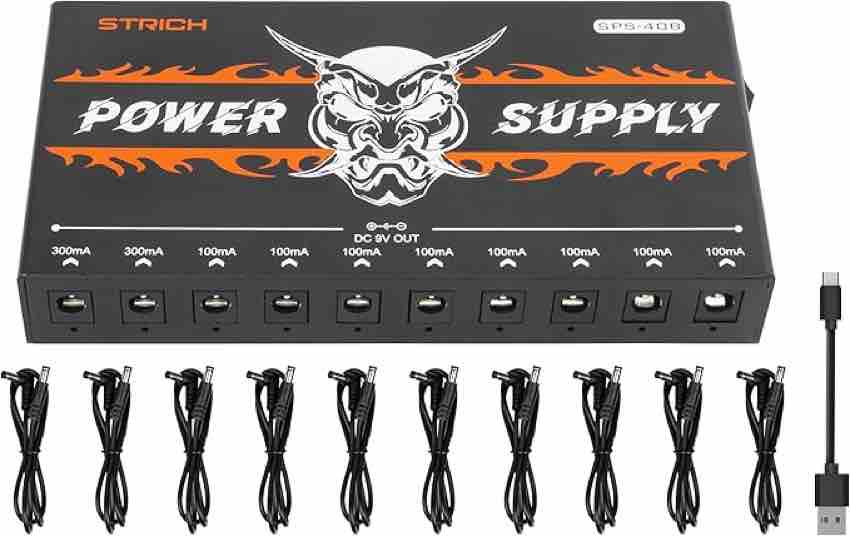 A sleek, rectangular black aluminum STRICH SPS-40B rechargeable pedal power supply. The top surface features the white 'STRICH' logo and a red power button. The front panel displays a row of 10 DC power outputs (9V) and a 5V USB-A port. Four small blue LED indicator lights on the side show the battery charge levels at 25%, 50%, 75%, and 100%.