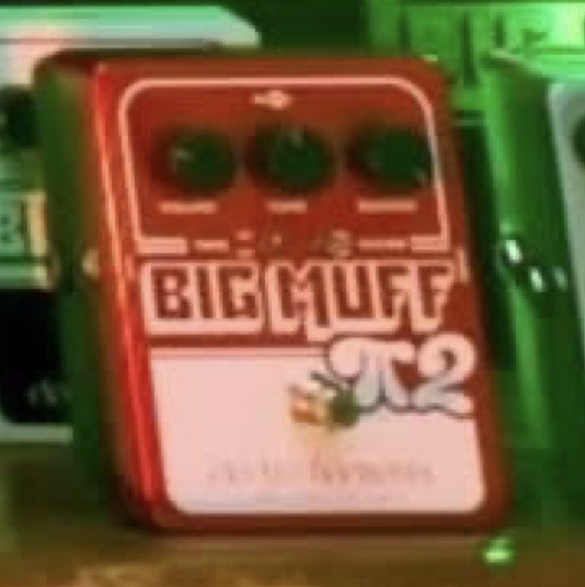 Close-up of a red Electro-Harmonix Big Muff 2 Tone Wicker pedal featuring three control knobs, two toggle switches, and the large "2" dual op-amp logo.