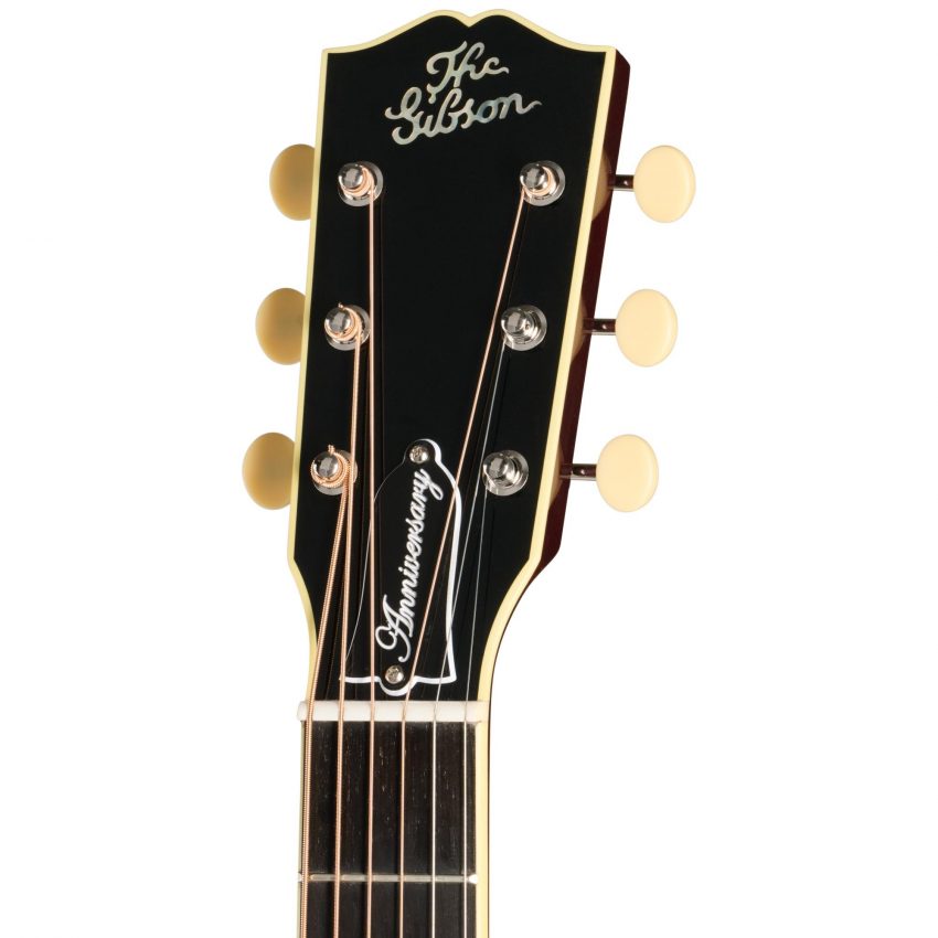 Detail shot of the Gibson L-1 Anniversary headstock featuring the vintage mother-of-pearl "The Gibson" logo, open-back tuners with cream buttons, and an engraved Anniversary truss rod cover.