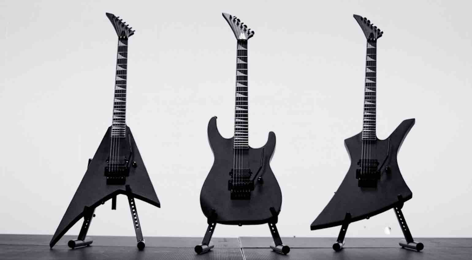 Three 2026 Jackson Pro Plus Pure Metal Stealth limited edition guitars—the Soloist, Kelly, and Rhoads—arranged together against a dark background, showcasing the all-black metal aesthetic.