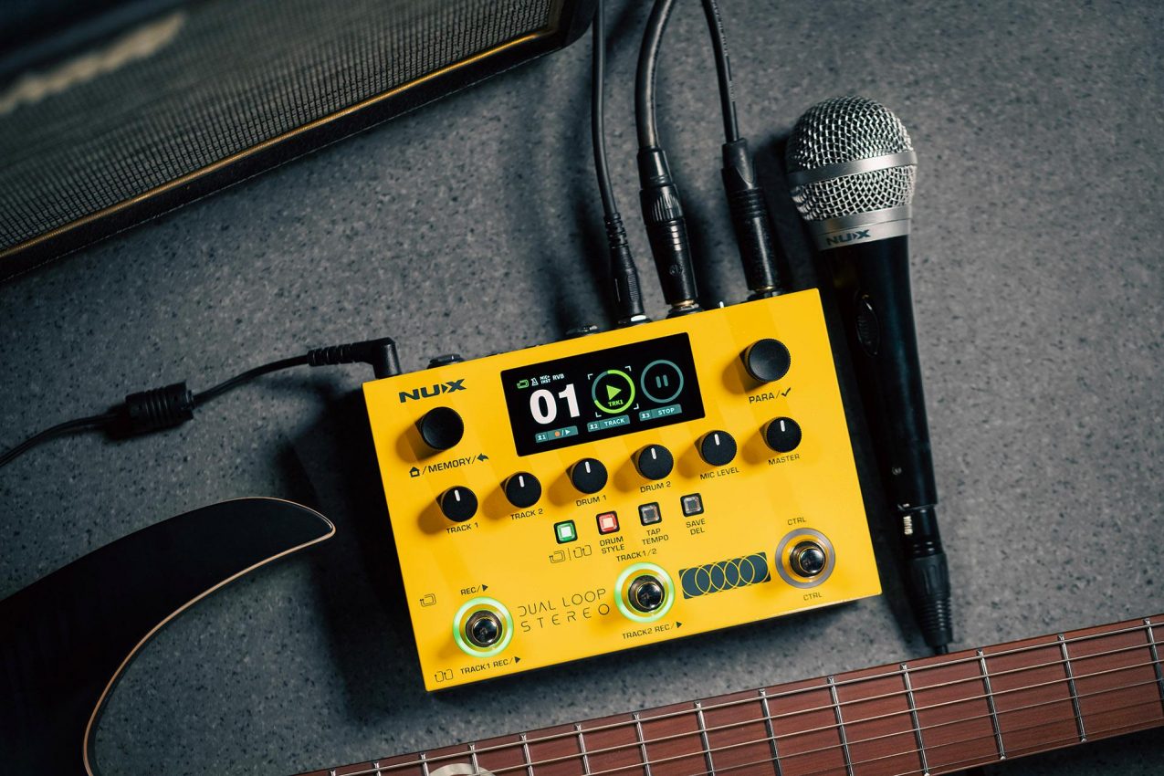 Top-down view of the NUX Dual Loop Stereo pedal featuring a high-resolution color LCD screen, six dedicated volume knobs, and three built-in footswitches on a yellow and black metal chassis