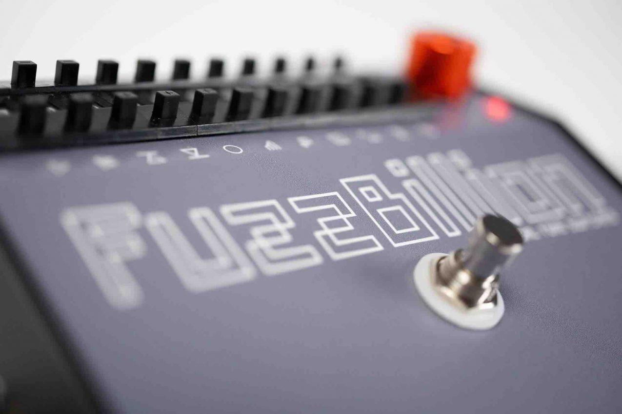 Close-up of the FuzzBillion pedal’s 11-wheel interface showing the clickable plungers for Gain Boost, Clipping Amplifiers, and PLL settings on an analogue stompbox.